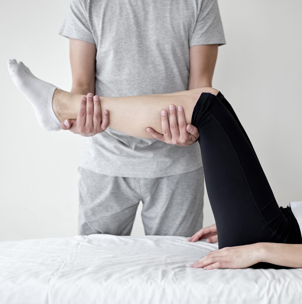 Patient performing controlled leg movement to improve mobility and lower body strength.